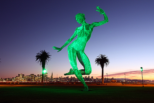 Bliss Dancing sculpture lit with San Francisco skyline in the background bliss, dancing, happiness, burning man